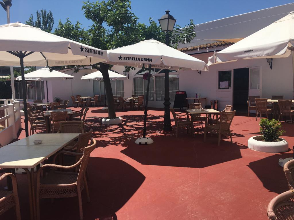 Terraza al mediodía bajo sombrillas blancas