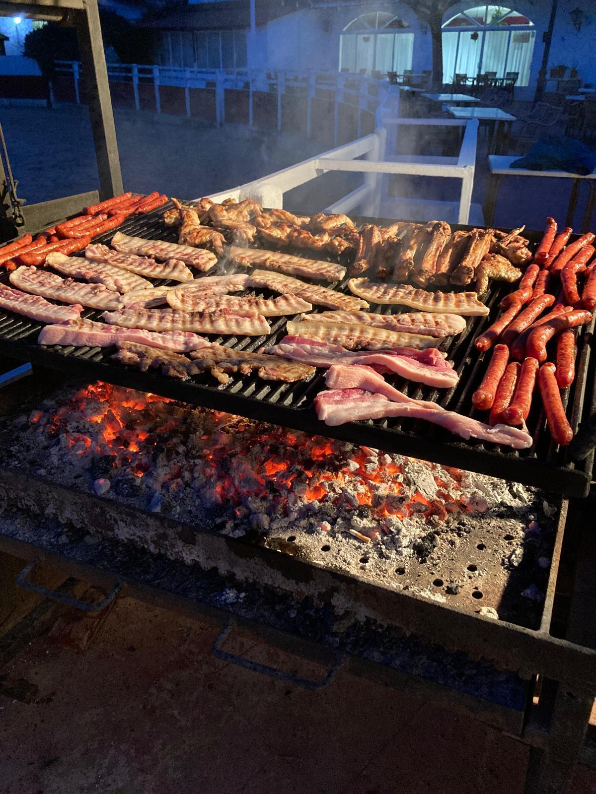 Parrilla de carnes a la brasa con brasas encendidas
